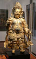 Gilded copper statue with gems of king guardian from Tibet at Guimet Museum. Paris, France.