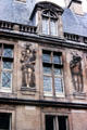 Human figure carvings on wall over courtyard at Carnavalet Museum. Paris, France.