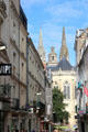 View of spires of St Maurice Cathedral over shops of rue Saint-Aubin. Angers, France.