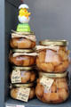 Jars of Baba au Rhum in shop window on Place St Croix. France.