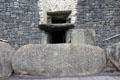 Passage tomb entrance guarded by Megalithic-carved swirl at Newgrange. Ireland