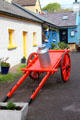 Decorative cart with milk can & vintage cottages in Dingle. Dingle, Ireland