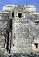 Tourists use chain to climb stairs of Temple of Magician at Uxmal. Mexico.