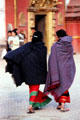 Cloaked women in front of Golden Gate in Durbar Square, Bhaktapur. Nepal.