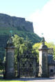 Holyrood Palace gates seen against Salisbury Crags volcanic rock formation of Arthur's Seat. Edinburgh, Scotland.