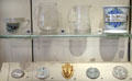 Ceramic, glass & metal souvenirs from Edinburgh International Exhibition badges at National Museum of Scotland. Edinburgh, Scotland.