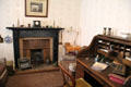 Parlor with black stone fireplace & roil-top desk in Reid farmhouse at National Museum of Rural Life. Kittochside, Scotland.