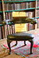 Library chair where reader sits backwards straddling seat, supporting book on back at Traquair House. Scotland.