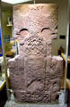 Pictish cross-slab shows swirling patters on cross flanked by Christian figures at St Vigeans Museum. Arbroath, Scotland.