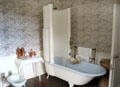 Bathroom with enclosing shower screen atop bathtub at Hill of Tarvit Mansion. Cupar, Scotland.