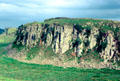 Hadrian's Wall dwarfed along top of rocky escarpment defended Roman Britannia from Pictish Scots. Scotland