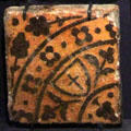 Inlaid clay cross on shield floor tile from Abbey in France at Gladstone Pottery Museum. Longton, Stoke, England.