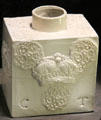 White tea canister of joined flat slabs with applied molded crown relief decoration & incised initials CT made in North Straffordshire at Potteries Museum & Art Gallery. Hanley, Stoke-on-Trent, England.