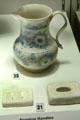 Dies for extruding handles & resulting salt-glazed stoneware jug with scratch blue decor bearing example of handle made in Staffordshire at Potteries Museum & Art Gallery. Hanley, Stoke-on-Trent, England.