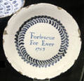 Tin-glazed earthenware plate painted with Fortescue For Ever. made in Bristol at Potteries Museum & Art Gallery. Hanley, Stoke-on-Trent, England.