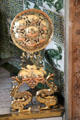 English brass andirons in shape of sunflowers supported by pair of griffins in drawing room at Wightwick Manor. Wolverhampton, England.
