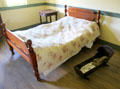 Bed & cradle in brick house at Ulster American Folk Park. Omagh, Northern Ireland.