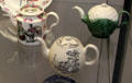 Creamware teapots from Staffordshire: transfer print fortune teller by William Greatbatch; transfer print tea party by Derby Pot Work; & cauliflower at British Museum. London, United Kingdom.