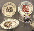 Transfer printed creamware plates by Wedgwood plus teapots not by Wedgwood from Staffordshire at British Museum. London, United Kingdom.