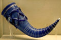 Blue glass drinking-horn with applied lattice work around neck & white trailing around body from Lombardy at British Museum. London, United Kingdom.