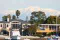 Seal Beach homes against distant snow-covered mountains. Long Beach, CA.