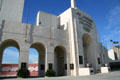Row of arches forming entrance of Memorial Coliseum with seating beyond. Los Angeles, CA.