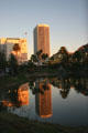 Buildings on Wilshire Boulevard reflect setting sun into La Brea tar pits. Los Angeles, CA.