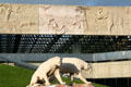 Reliefs of ancient life around La Brea Tar Pits on facade of Page Museum of La Brea Discoveries above Saber Tooth Tiger sculptures. Los Angeles, CA
