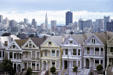 Skyline of downtown over Victorian houses on Alamo Square. San Francisco, CA.