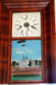 Ornate wood framed wall clock with painting of the old New York State Capitol building at Calaveras County Downtown Museum. San Andreas, CA.