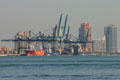 Cranes of port of Miami container docks with Miami Beach beyond. Miami, FL.