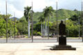 Statue of Father Damien looks at armed services memorial & Punchbowl crater. Honolulu, HI.
