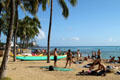 Sun bathers along beach in Waikiki. Waikiki, HI.