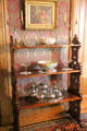 Shelves with China, glass & silver tea service at Dodge House. Council Bluffs, IA.
