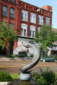 Sculpture of swimming catfish & building with deer head. Clinton, IA.