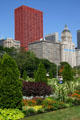 Red CNA Plaza, McCormick, & Metropolitan buildings over gardens of Grant Park. Chicago, IL.