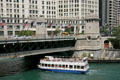 Tour boat passes under Michigan Avenue Bridge over Chicago River. Chicago, IL