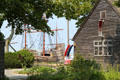 Mayflower II replica sits beside early American building replica. Plymouth, MA.