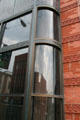 Modern curved glass front on antique brick wall of Hennessy Building. Butte, MT.