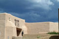 Museum of Indian Arts & Culture in sun under threatening sky. Santa Fe, NM