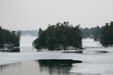 Some of Thousand Islands in St. Lawrence River ringed by ice seen from International Bridge. NY.