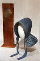 Shaker coffin wall clock & sister's bonnet from New Lebanon, NY at Metropolitan Museum of Art. New York, NY.