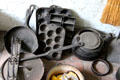 Cast iron kitchen utensils including toast rack & muffin tins in Powell House at Old Bethpage Village. Old Bethpage, NY.