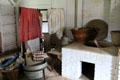 Wash shed with clothes boiling vat over fireplace in Powell House at Old Bethpage Village. Old Bethpage, NY.