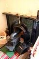 Coal stove inserted into a fireplace with a coal scuttle at Taft House NHS. Cincinnati, OH.