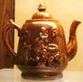 Rockingham teapot with raised woman at well relief at Museum of Ceramics. East Liverpool, OH.