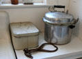 Burpee can sealer pressure cooker beside ice tongs in Staiti House at Sam Houston Park. Houston, TX.