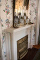 Fireplace in bedroom with floral wallpaper at McFaddin-Ward House. Beaumont, TX.
