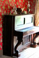 Upright piano in gentleman's parlor in Bell House at Pioneer Farms. Austin, TX.