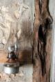 Oil lamp hanging on rustic wall in Locksted-Seibold house at Conservation Plaza. New Braunfels, TX.